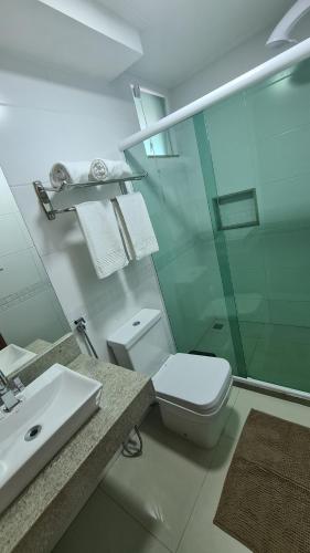 a bathroom with a toilet and a sink and a shower at Pousada Caminho do Mar in Cabo Frio