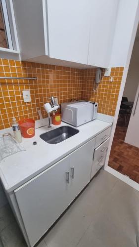 een keuken met een wastafel en een magnetron bij Apê in Copacabana in Rio de Janeiro