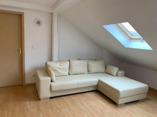 a white couch in a room with a skylight at Cozy Little One Room Appartment, a tranquil haven! in Mulhouse
