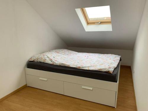 a small bed in a room with a window at Cozy Little One Room Appartment, a tranquil haven! in Mulhouse