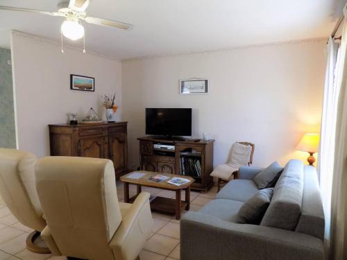 un salon avec un canapé et une télévision dans l'établissement Royan - MAISON de PLAIN-PIED avec jardin clos - QUARTIER RESIDENTIEL, à Royan
