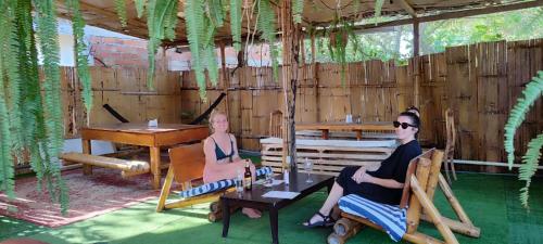 two women sitting in chairs in a room with a piano at Casa travesia in Ayampe