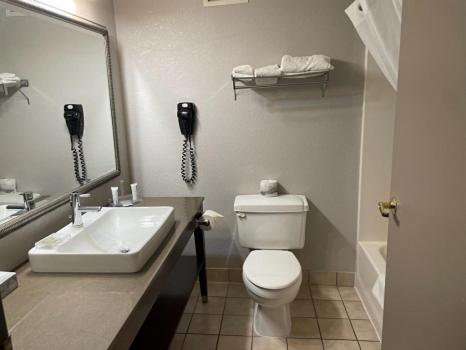 a bathroom with a sink and a toilet and a phone at AmeriVu Inn & Suites - Shakopee in Shakopee