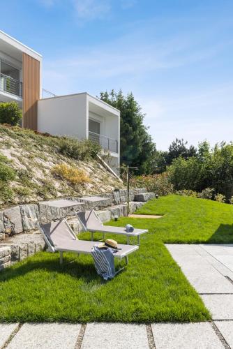 a garden with two lounge chairs and a house at Residence Conca Verde 2 with pool in Trarego Viggiona