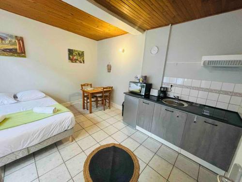 Il comprend une chambre avec un lit et une cuisine avec un évier. dans l'établissement Une pause en baie de Somme, rez de chaussée, Wifi, à Abbeville