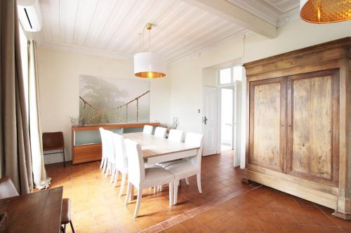 a dining room with a table and white chairs at Casa Mahalia - Calme et Campagne in Carril