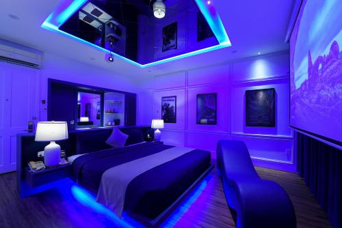 ダナンにあるChiic House 3 - Khách sạn tình yêuの紫色のベッドルーム(ベッド1台、テレビ付)