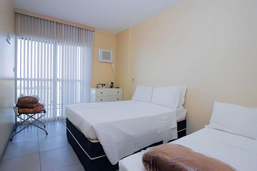 a hotel room with two beds and a balcony at Ozped Private Flats Manhatan in Brasília