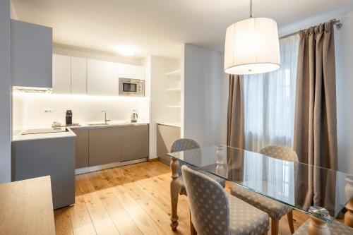a dining room and kitchen with a glass table and chairs at Chalet Falorie in Cortina dʼAmpezzo