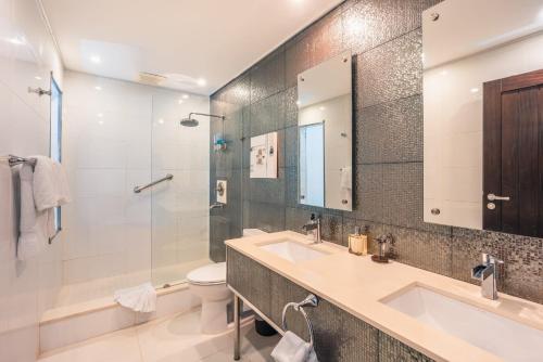 ein Badezimmer mit einem Waschbecken, einem WC und einem Spiegel in der Unterkunft Breakfast Included Marina Town House at Puerto Bahia in Santa Bárbara de Samaná
