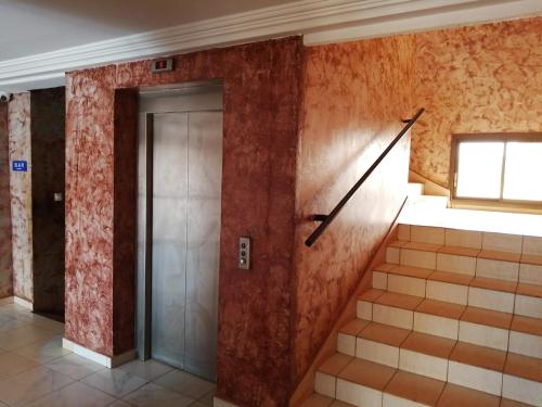 un couloir avec ascenseur dans un immeuble dans l'établissement MAKO PALACE Hôtel, à Bafoussam