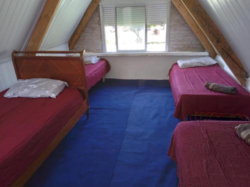 a attic room with two beds and a window at LAPOSTa555 in Piriápolis