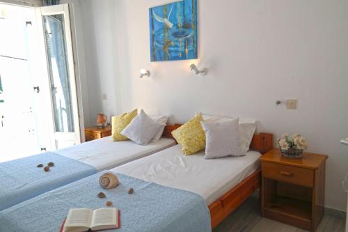 a bedroom with two beds with books on them at Sanoudos in Naxos Chora