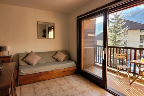sala de estar con sofá en el balcón en Joli nid de ski à La Salle-les-Alpes, en La Salle-les-Alpes
