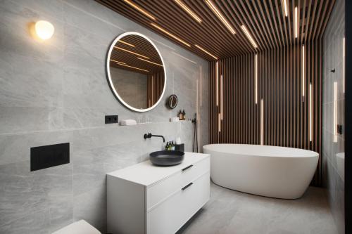 a bathroom with a tub and a sink and a mirror at Hotel Klaustur in Kirkjubæjarklaustur