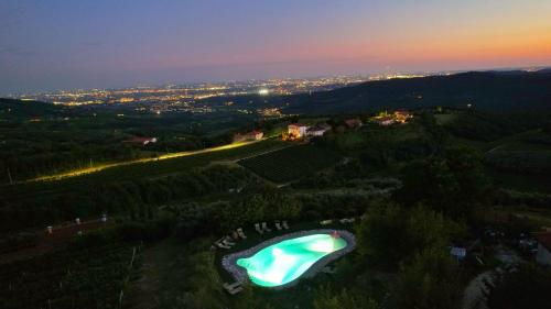 una vista sulla piscina su una collina di notte di Agriturismo La Perlara - Adults Only a Verona