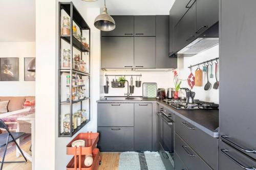 a small kitchen with gray cabinets and a stove at Appartamento a Val di Sopra, Cortina d'Ampezzo in Cortina dʼAmpezzo