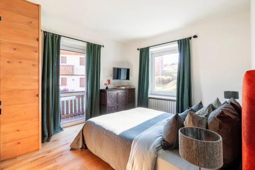 een slaapkamer met een bed en 2 grote ramen bij Appartamento a Val di Sopra, Cortina d'Ampezzo in Cortina dʼAmpezzo