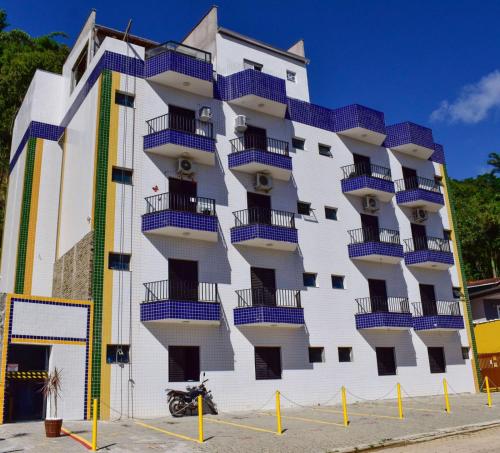 a building with blue balconies on the side of it at Apartamento Mar Brasil II in Ubatuba
