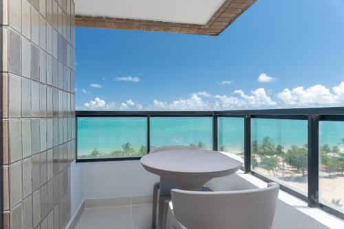 a room with a table and chairs and a view of the ocean at Vistamar Hotel in Maceió
