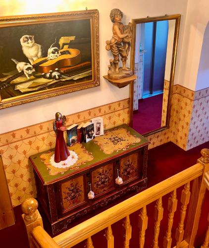 a stairway with a dresser and a painting on the wall at Hotel Garni Concordia - Dolomites Home in Selva di Val Gardena