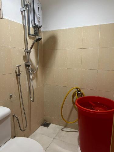 a shower in a bathroom with a toilet and a bucket at Homestay GG Greenwood Gombak in Batu Caves