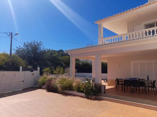 a house with a patio with a table and chairs at Villa Carpe Diem (Seize the day) in Carvoeiro