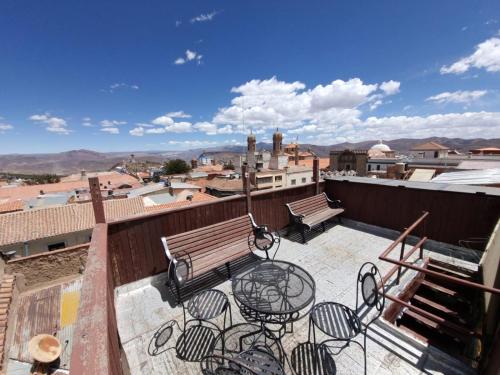 a balcony with a bench and tables and chairs at Hostal Imperial Carlos V in Potosí