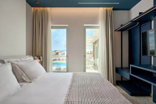 Schlafzimmer mit einem Bett und Poolblick in der Unterkunft Helius Villas in Aliki