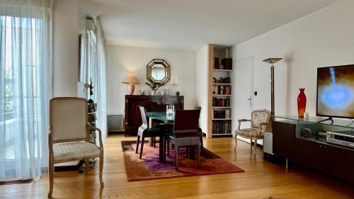 - un salon avec une table, des chaises et un miroir dans l'établissement Chez Nicole & Denis, à Boulogne-Billancourt