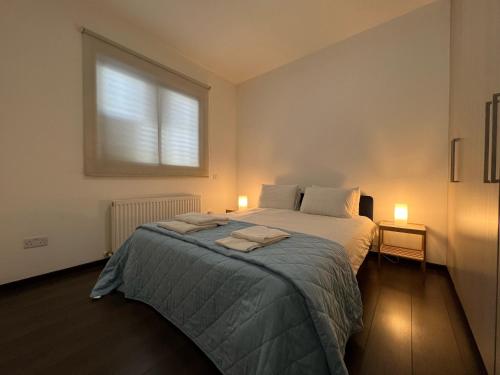 a bedroom with a bed with two towels on it at Majestic Boutique Apartment/2BR in Nicosia