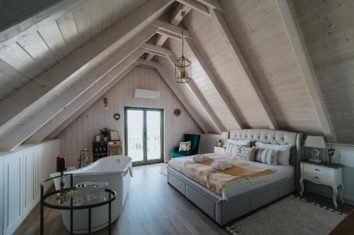 1 dormitorio con 1 cama grande en el ático en Lovassy Lodge, en Lovas