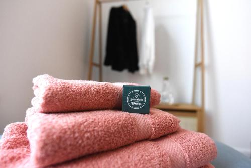 une pile de serviettes roses avec une boîte au-dessus dans l'établissement At Huis, à Boeschèpe