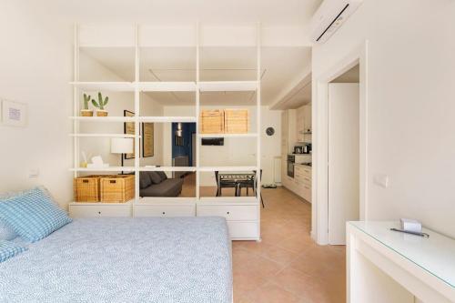 1 dormitorio blanco con 1 cama y cocina en Brand new large studio with parking - Opera studio en Milán