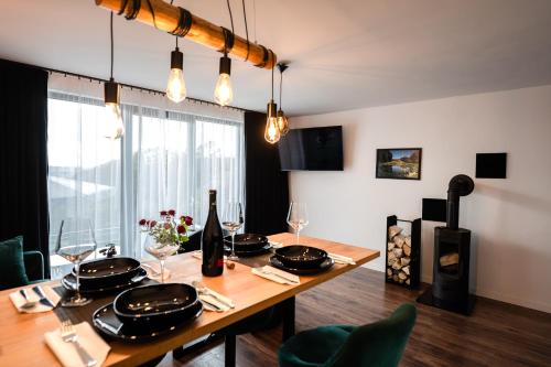 - une salle à manger avec une table, des bouteilles de vin et des verres dans l'établissement Apartament Dąbrówka w Winiarni, à Dąbrówka Szczepanowska