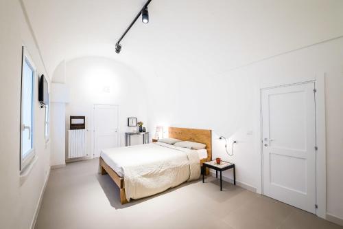 a white bedroom with a bed and a table at B&B Casa Ninè in Gioia del Colle