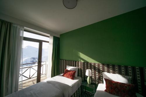 um quarto verde com 2 camas e uma janela em Chalet Papa Basili em Gudauri