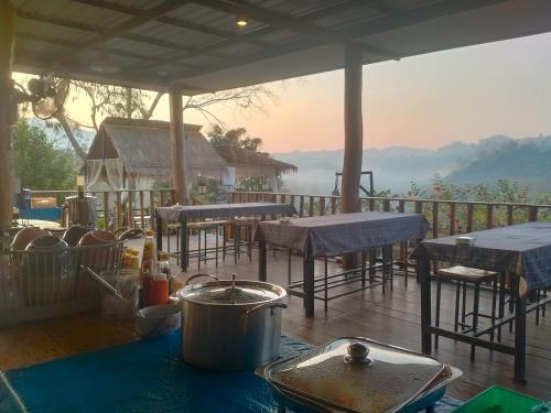 a table with a pot on top of a deck at Doi Sang Farm Stay - ดอยซางฟาร์มสเตย์ in Ban Huai Kom