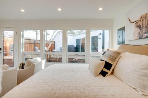 een witte slaapkamer met een groot bed en ramen bij Napa Studio with Shared Hot Tub Close to Wineries! in Napa