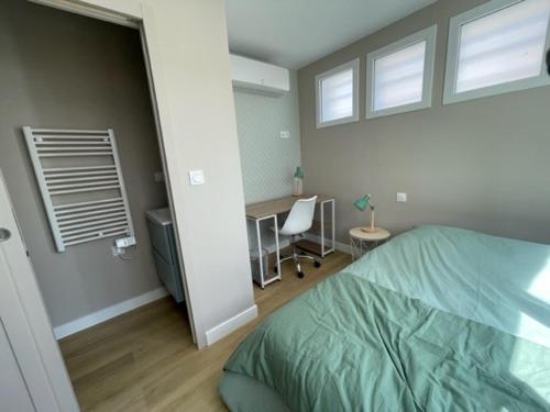 a bedroom with a bed and a desk with a chair at Charmante maison rénovée en plein centre in Saint-Nazaire