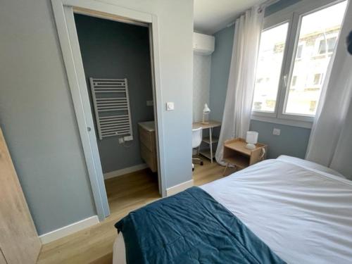 a bedroom with a bed and a window and a desk at Charmante maison rénovée en plein centre in Saint-Nazaire