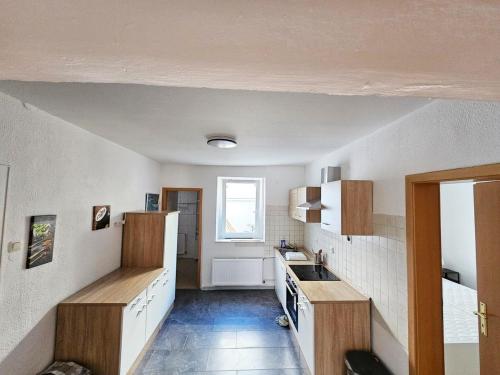 a kitchen with white walls and wooden cabinets and a window at Ferienwohnung in zentraler Lage in Frechen