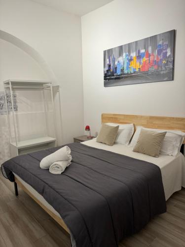 a bedroom with two beds and a painting on the wall at Corte Capuana in Catania