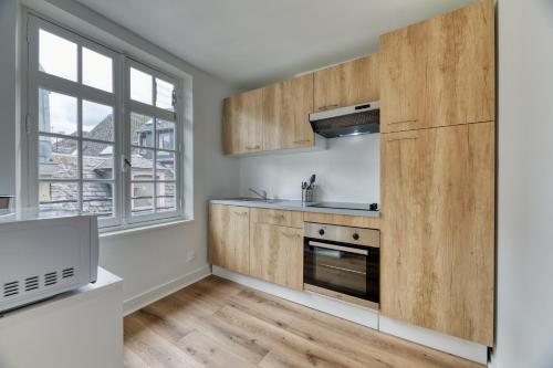 - une cuisine avec des murs blancs et des placards en bois dans l'établissement Damiette charmant F4 centre Rouen St Maclou !, à Rouen