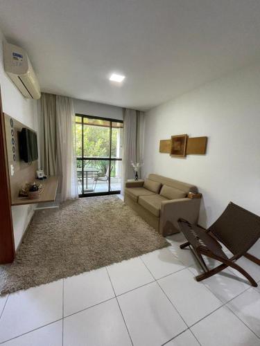 - un salon avec un canapé, une table et une télévision dans l'établissement ILOA RESIDENCE I APT 107K, à Barra de São Miguel