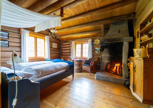 a bedroom with a bed and a fireplace at Røisheim Hotel & Skysstasjon in Lom