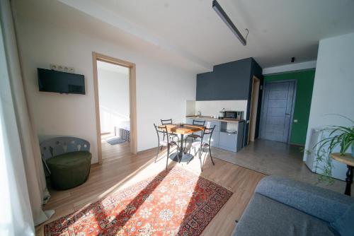 a living room with a table and a kitchen at Chalet Papa Basili in Gudauri