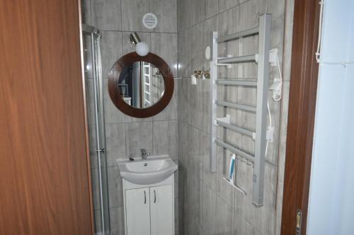 ein Bad mit einem Waschbecken und einem Spiegel in der Unterkunft Mały Biały Domek in Darłowo