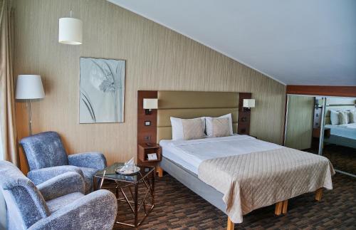a hotel room with a bed and a chair at Olympus Hotel in Kaunas