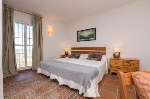 een slaapkamer met een groot bed en een raam bij La Galbana Vejer in Vejer de la Frontera